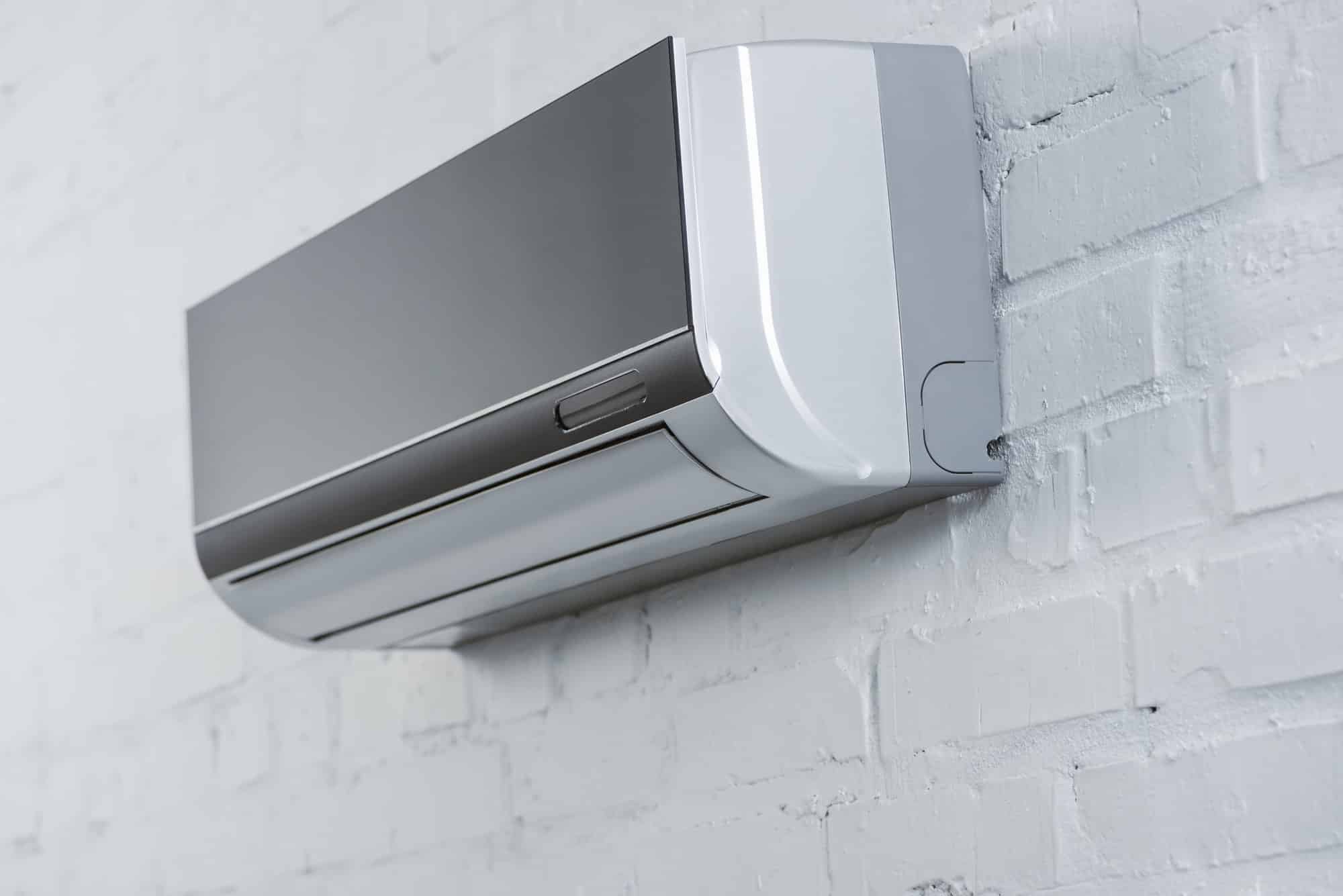 close-up-shot-of-grey-air-conditioner-hanging-on-white-brick-wall.jpg