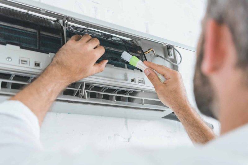 selective-focus-of-repairman-cleaning-air-conditioner-with-brush.jpg